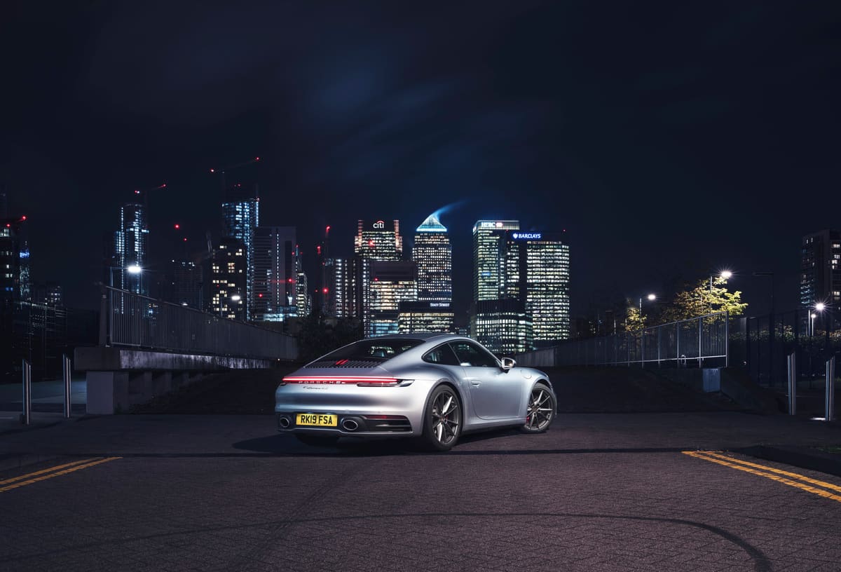 Porsche 911 (992) parked overlooking the Canary Wharf skyline at night